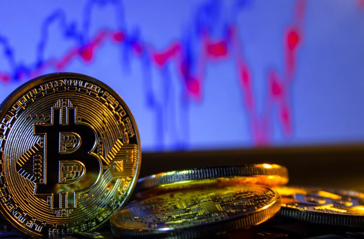 A golden bitcoin with keyboard and graph background. trading concept of crypto currency