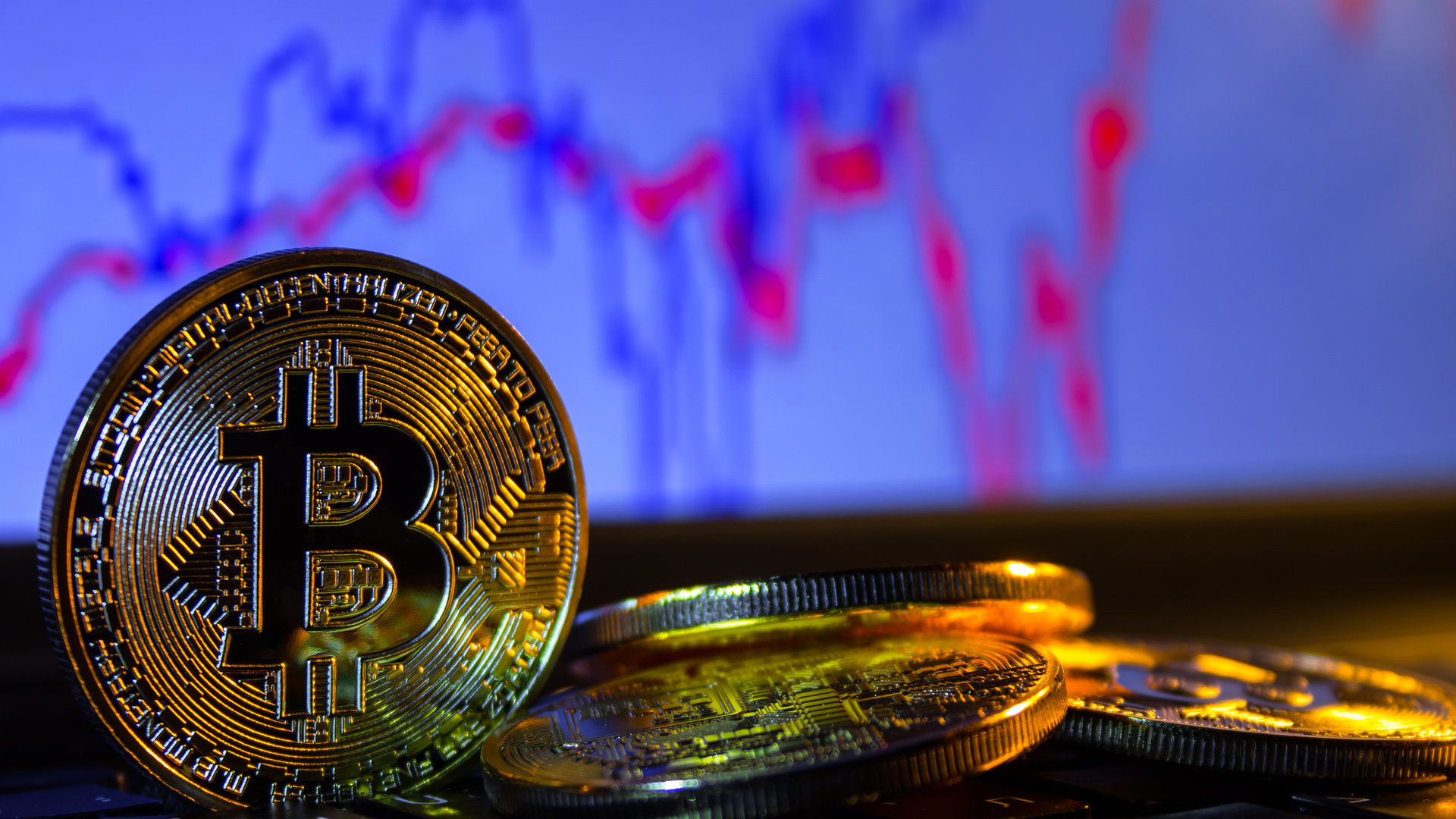 A golden bitcoin with keyboard and graph background. trading concept of crypto currency